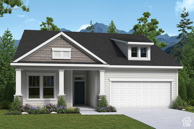 View of front facade featuring a garage, a front lawn, and a mountain view