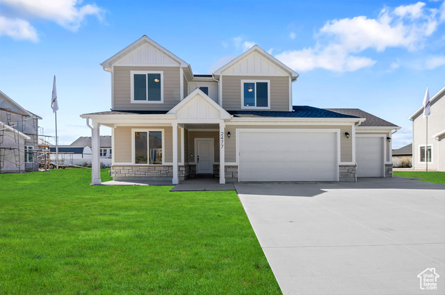 Craftsman-style home with a garage, a front yard, and covered porch