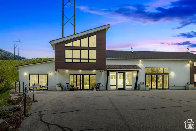 Back house at dusk with a patio and french doors