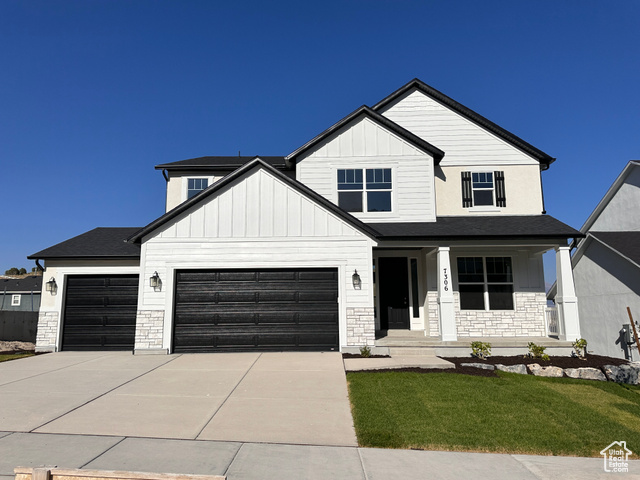 Modern farmhouse style home featuring covered porch and a front lawn