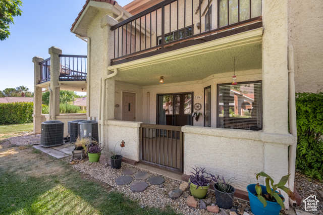 Doorway to property with a balcony and central AC unit