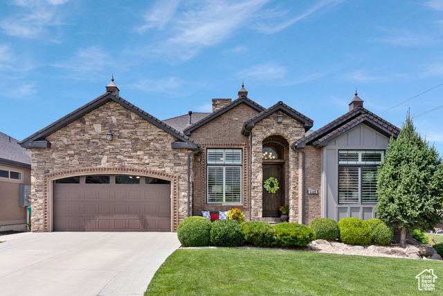 View of front of home with a garage and a front lawn