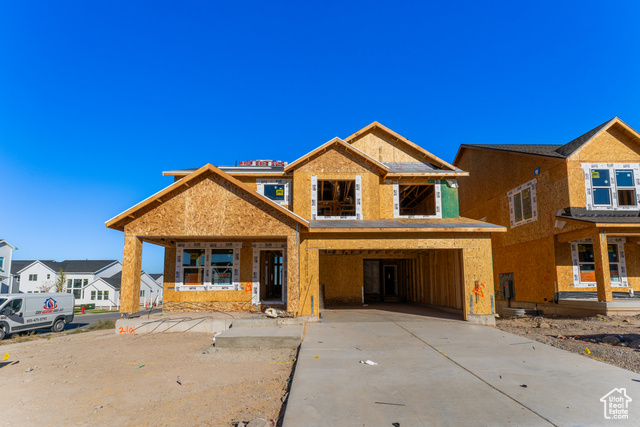 Property in mid-construction with a carport and covered porch