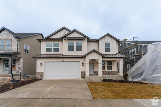 View of front of property featuring a front yard and a garage