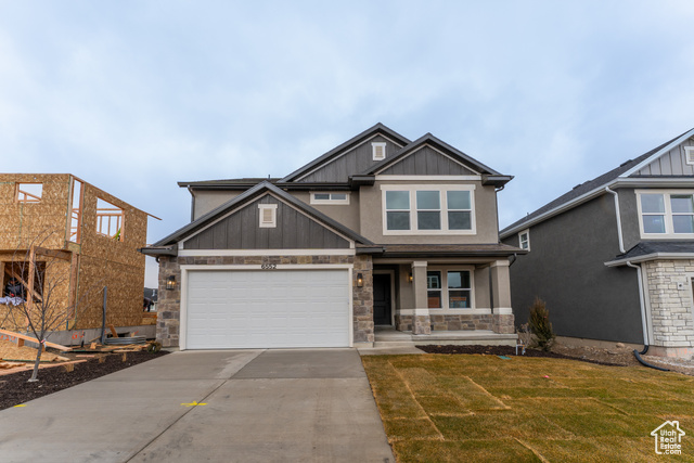 View of front of house with a front yard and a garage