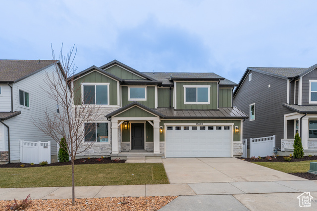 View of front facade featuring a garage and a front lawn