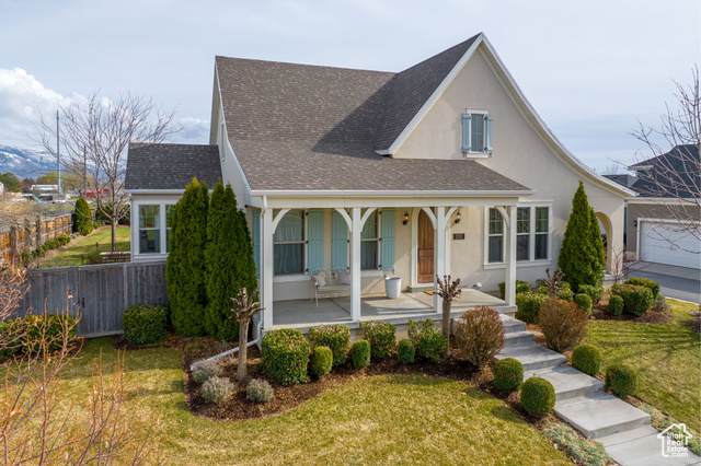 View of front of property featuring a garage and a front yard