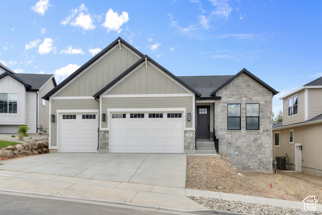 View of front of house featuring a garage and central AC unit