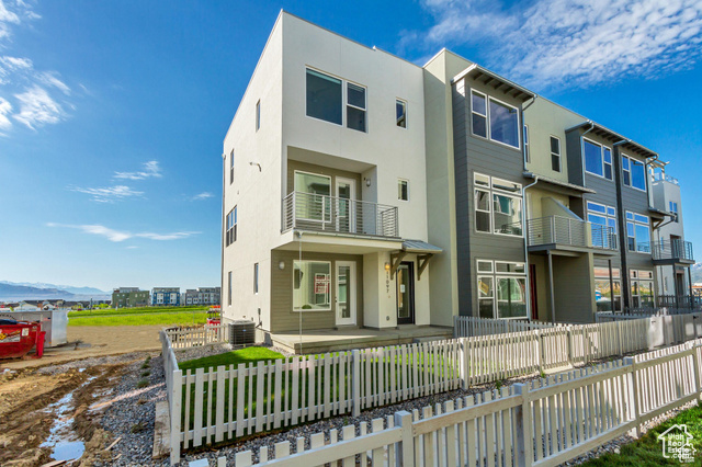 Rear view of property with a balcony and cooling unit