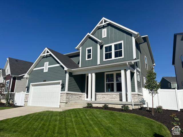 Craftsman-style home with a front lawn, a porch, and a garage