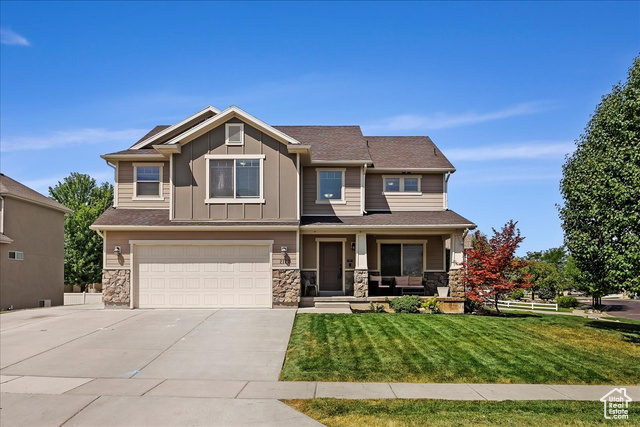 Craftsman inspired home with a garage and a front yard