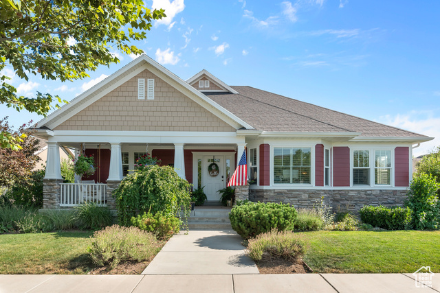 Craftsman inspired home featuring a porch and a front lawn