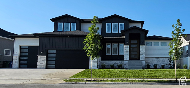 View of front of property with a garage and a front lawn