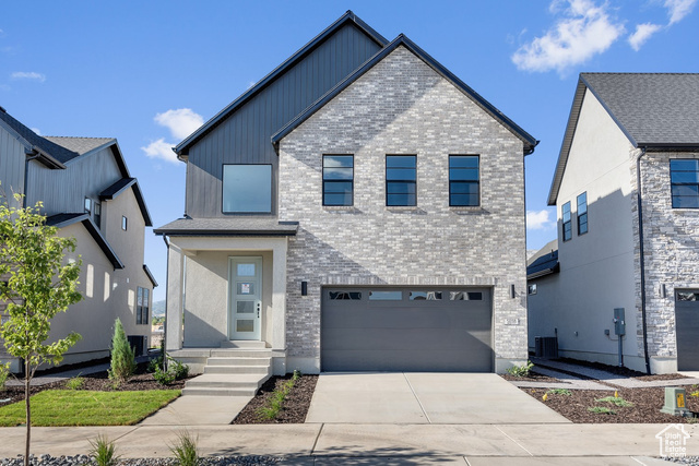 View of front of home featuring central AC and a garage