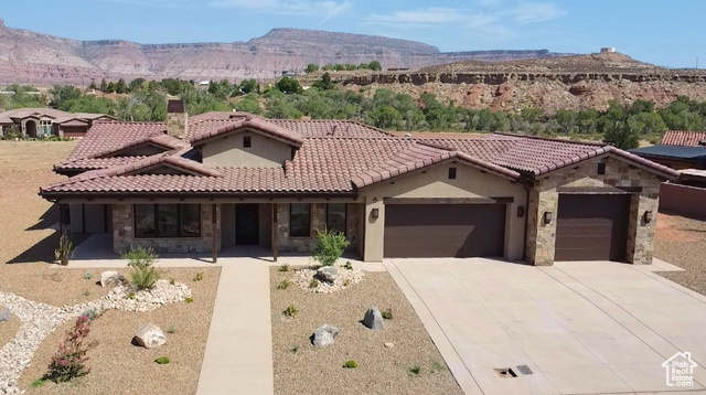 View of front of property with a mountain view and a garage