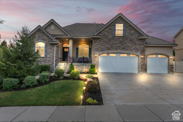 View of front of property with a yard and a garage