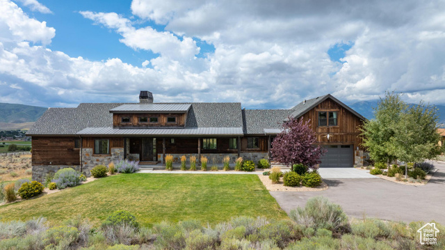 View of front of property featuring a garage and a front yard