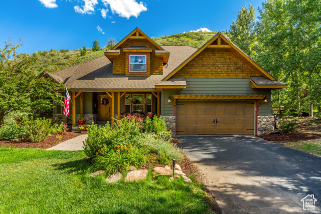 Craftsman-style house with a front lawn and a garage