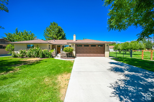 Ranch-style house with a garage and a front yard