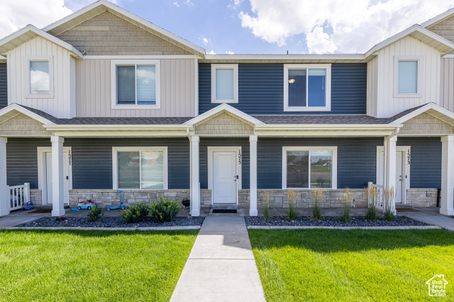 Craftsman-style home with covered porch and a front lawn