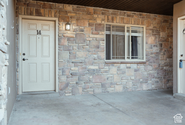 Main Level Condo, Doorway to property featuring a patio.  Storage shed on right.