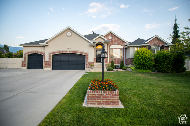 View of front of home featuring a front lawn and a garage