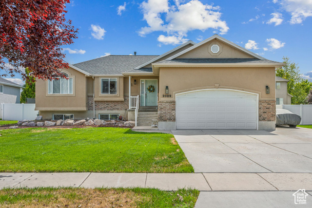 View of front of home featuring a front lawn and a garage