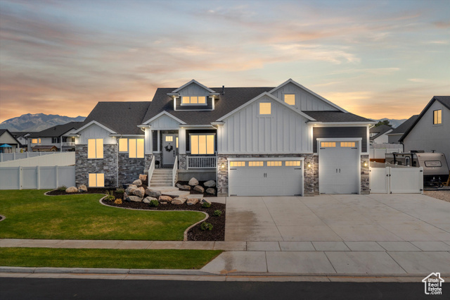 View of front facade with a garage and a yard