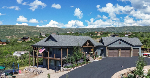 View of front of house featuring a trampoline, a garage, and a mountain view