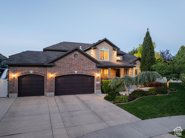 View of front of property featuring a front lawn and a garage