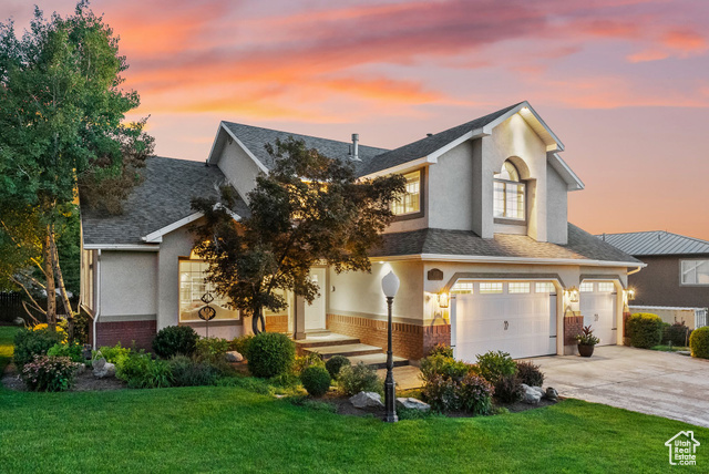 View of front of house featuring a yard and a garage