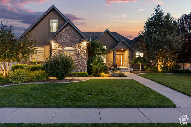 View of front of house with a garage and a lawn