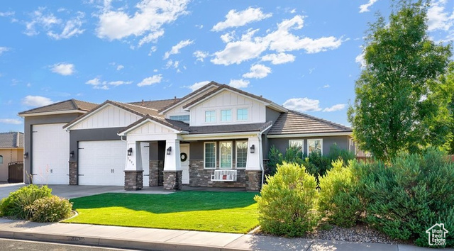 View of front of property featuring a garage and a front lawn