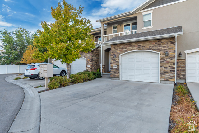 View of front of property featuring a balcony and a garage