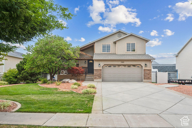 View of property with a garage and a front yard