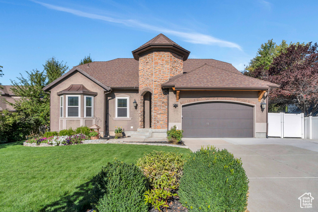 View of front of house featuring a garage and a front yard