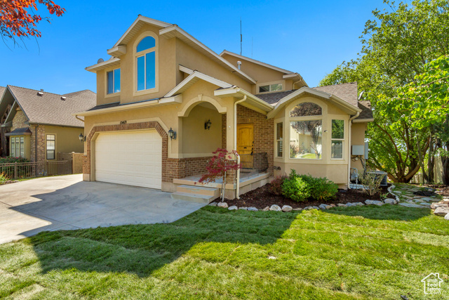 View of front of house with a garage and a front yard