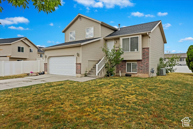 View of front of property featuring a front yard and a garage