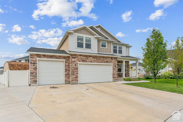 Craftsman inspired home with a garage and a front yard