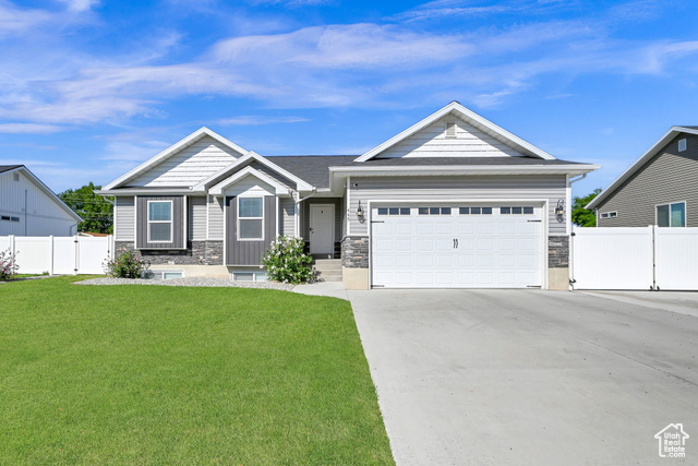 Craftsman inspired home with a garage and a front yard