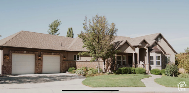 View of front of home with a garage and a front lawn