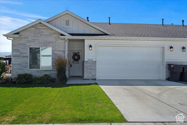 View of front of house with a garage and a front lawn