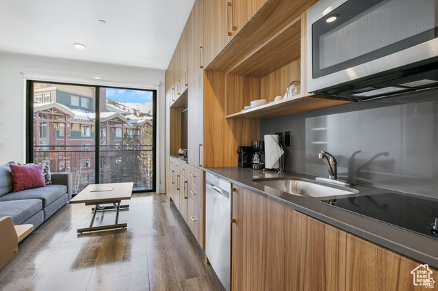 Kitchen with dark wood-type flooring, stainless steel appliances, and sink