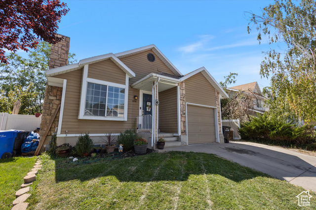 View of front of house featuring a garage and a front yard