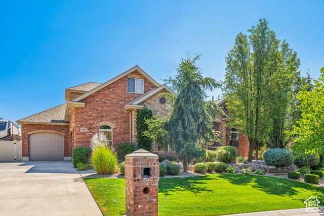 View of front of property featuring a front yard and a garage