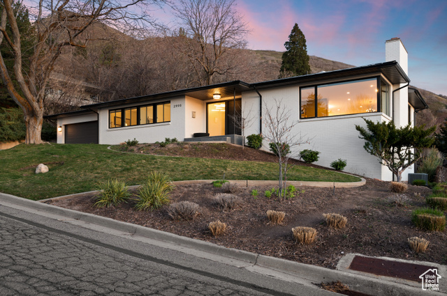 View of front facade featuring a yard and a garage