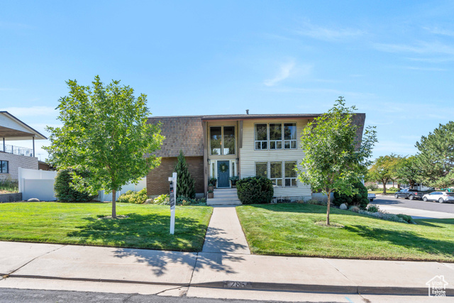 View of front of home with a front lawn, large corner lot