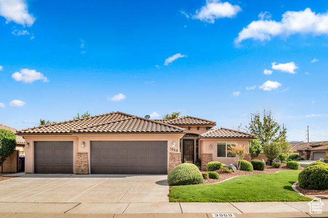 Mediterranean / spanish house featuring a garage and a front yard