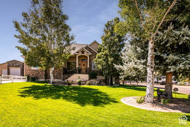 View of front of house with a front yard and a garage