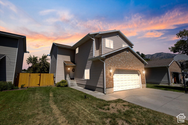 Front of property with a garage and a yard